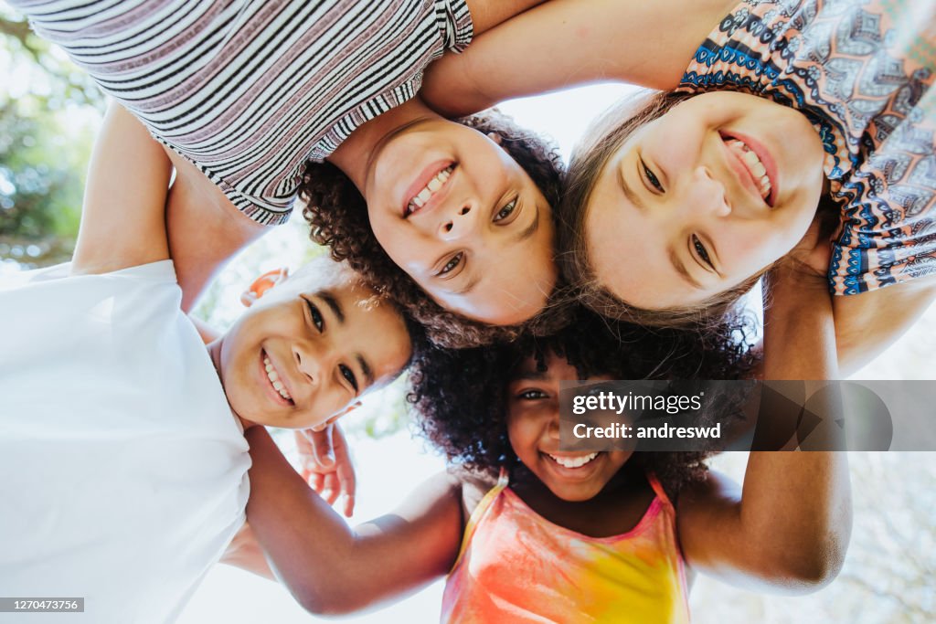 Grupo de crianças sorrindo e olhando para a diversidade da câmera