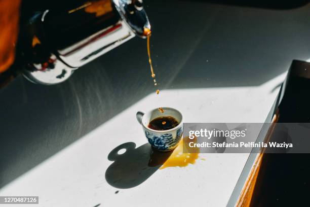 coffee spilled outside the espresso cup as a mistake - prueba de tinción fotografías e imágenes de stock