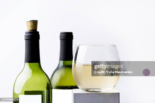 wine bottles and glass of wine on a pedestal. mockup. - champagne label stock pictures, royalty-free photos & images