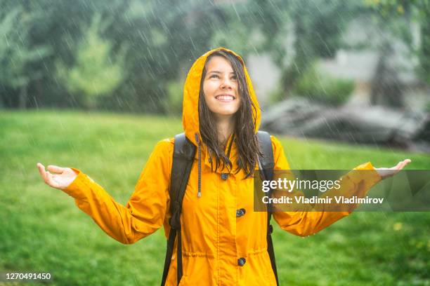 feliz jovencita divirtiéndose bajo la lluvia - empapado fotografías e imágenes de stock