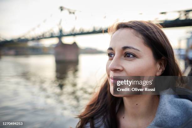thoughtful woman at the riverside in the city - seitenblick stock-fotos und bilder