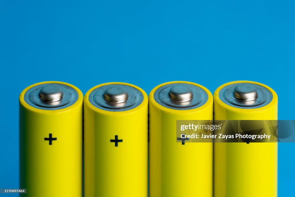 Four Yellow Batteries On Blue Blackground