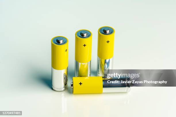 four yellow batteries on white blackground - single use ストックフォトと画像