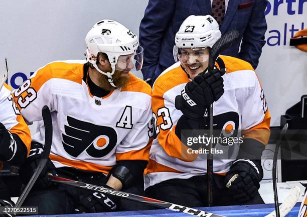 Oskar Lindblom of the Philadelphia Flyers shares a laugh with Jakub Voracek during a timeout against the New York Islanders during the first period...