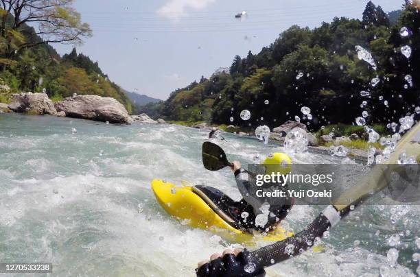 three river kayakers running down the white water so excited with a splash in good weather - canoe fotografías e imágenes de stock