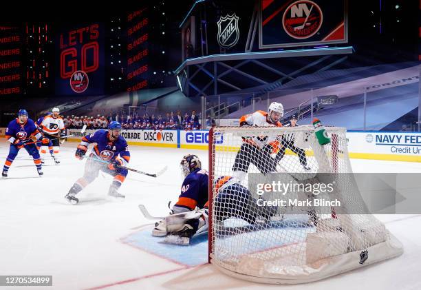 Scott Laughton of the Philadelphia Flyers scores on a breakaway against goaltender Semyon Varlamov of the New York Islanders in the third period of...