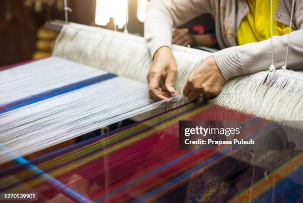 close up of woman weaving silk from hand weaving machine, abstract background - selective focus, thailand - loom stock pictures, royalty-free photos & images