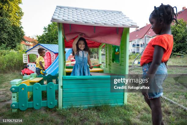 children have fun in a playhouse in back yard - casa de brinquedo imagens e fotografias de stock