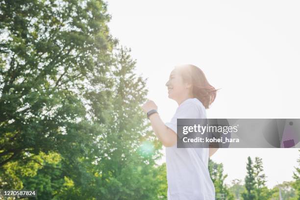 vrouw die in het park loopt - sports nippon stockfoto's en -beelden