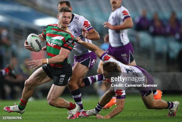 Damien Cook of the Rabbitohs is challenged by Ryan Papenhuyzen of the Storm during the round 17 NRL match between the South Sydney Rabbitohs and the...