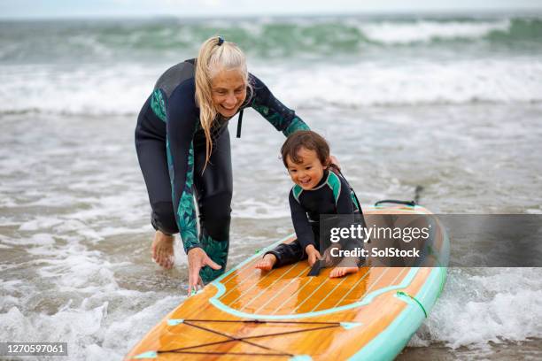 avontuurlijke grootmoeder - surfer wetsuit stockfoto's en -beelden