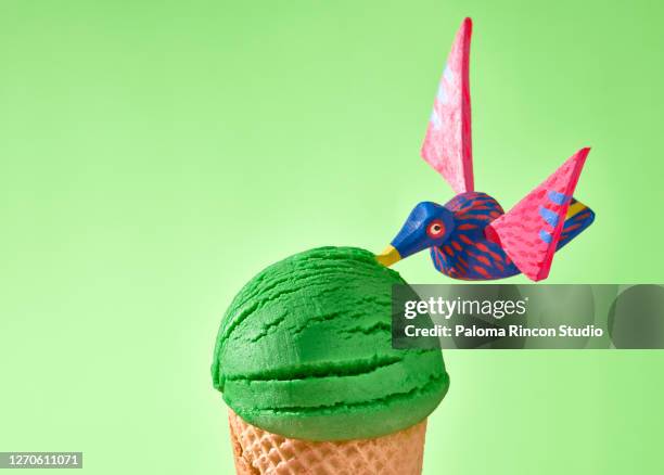 a green ice cream closeup decorated with mexican handcrafts over a green background. - alebrije stock-fotos und bilder