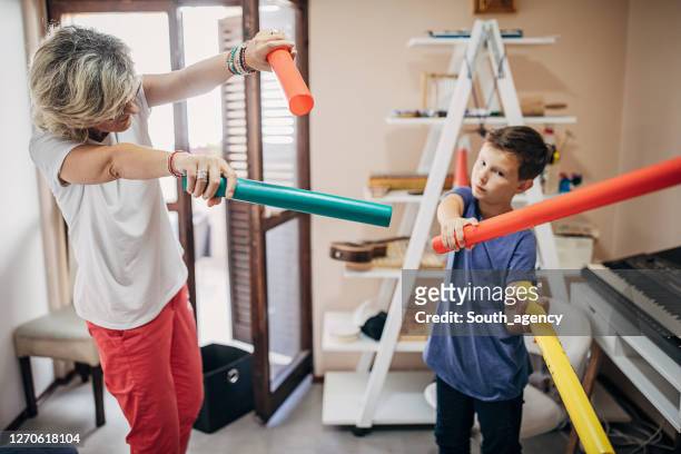 boy with female teacher on music class - music therapy stock pictures, royalty-free photos & images