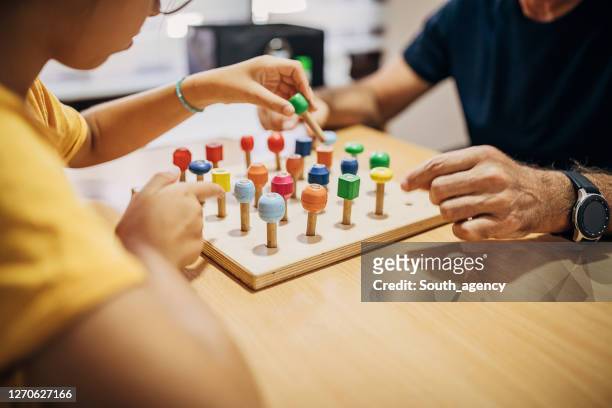kleuter leren kleuren met ergotherapeut - man sitting at a desk craft stockfoto's en -beelden