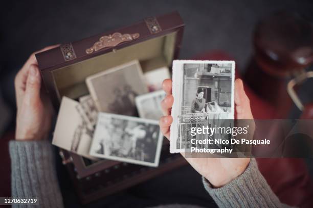 senior woman discovering old photographs - nostalgie photos et images de collection