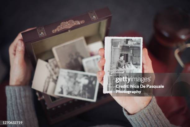 senior woman discovering old photographs - old memories stock pictures, royalty-free photos & images