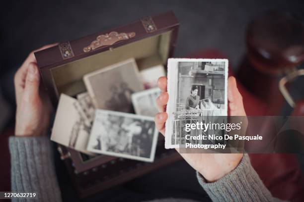 senior woman discovering old photographs - women's history stock pictures, royalty-free photos & images