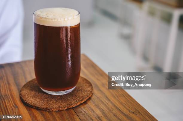 a nitro cold brew coffee on the wood table in cafe shop. - nitro stock-fotos und bilder