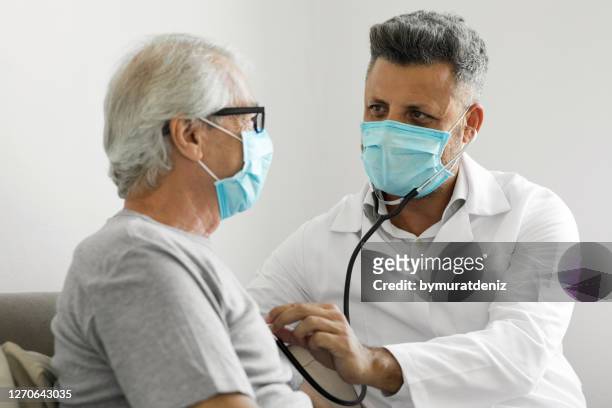 health visitor and a senior man during home visit - human heart stock pictures, royalty-free photos & images
