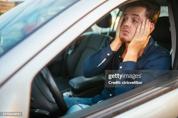 a young man desperately waits in the traffic jam - car traffic imagens e fotografias de stock