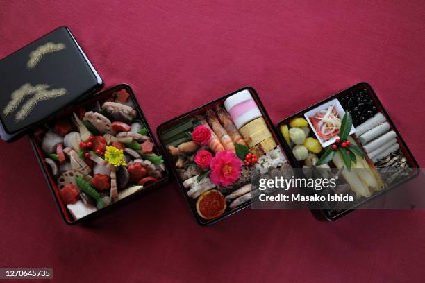 handmade osechi   - traditional japanese new year's dishes  packed in three-tiered traditional japanese lacquer coating jubako boxes ( aizu lacquer coating ) - osechi ryori stock-fotos und bilder