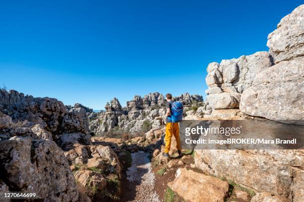 young man on a hiking trail, limestone rock formations, el torcal nature reserve, torcal de antequera, malaga province, andalusia, spain - paraje natural torcal de antequera stock-fotos und bilder
