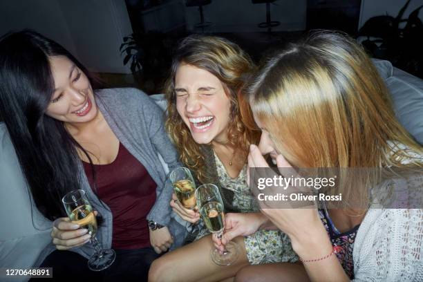 three happy women sitting on couch drinking champagne - champagne party stock pictures, royalty-free photos & images