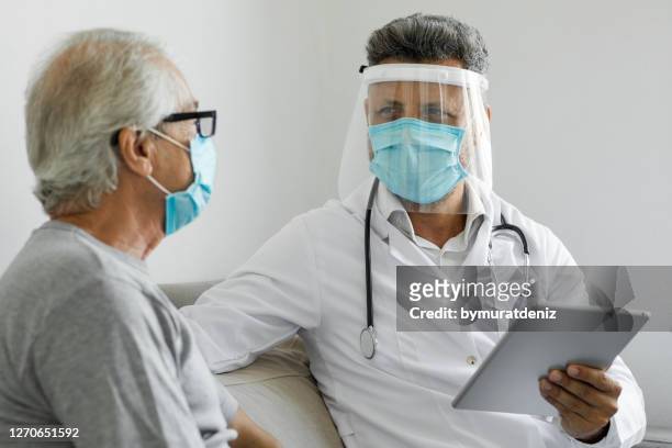 doctor visiting his patient at his home - respiratory disease stock pictures, royalty-free photos & images