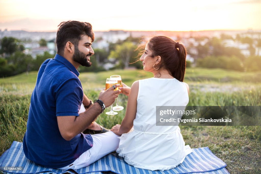 Young pretty couple drinking wine outdoors.