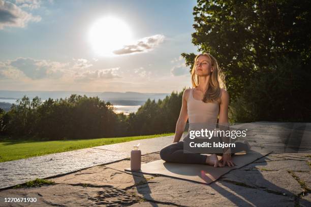 young sporty woman practicing yoga by doing single pigeon exercise, eka pada raja kapotasana. - yin yang symbol stock pictures, royalty-free photos & images