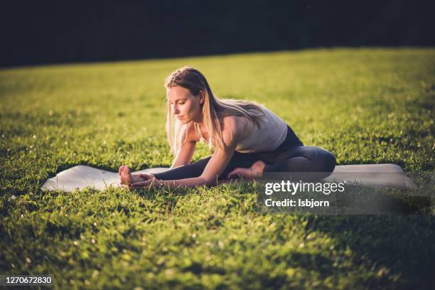 sporty beautiful young woman doing hamstring stretch exercise. - yin yang symbol stock pictures, royalty-free photos & images