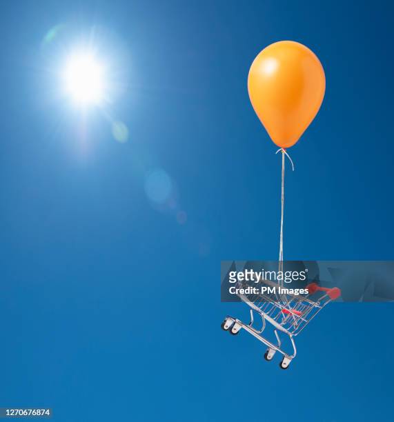 shopping cart being carried by balloon - helium stock pictures, royalty-free photos & images