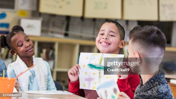 elementary students in art class, showing off artwork - holding aloft stock pictures, royalty-free photos & images