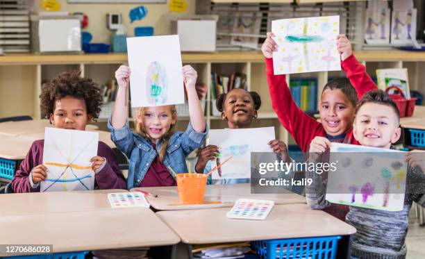 elementary students in art class, holding up artwork - art class stock pictures, royalty-free photos & images