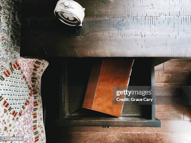 bible in open nightstand drawer in bedroom - schublade stock-fotos und bilder