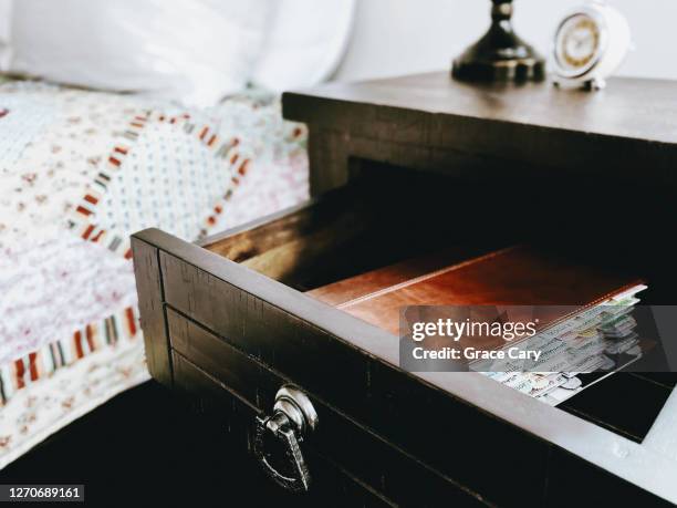 bible in open nightstand drawer in bedroom - reading bible in bed photos et images de collection