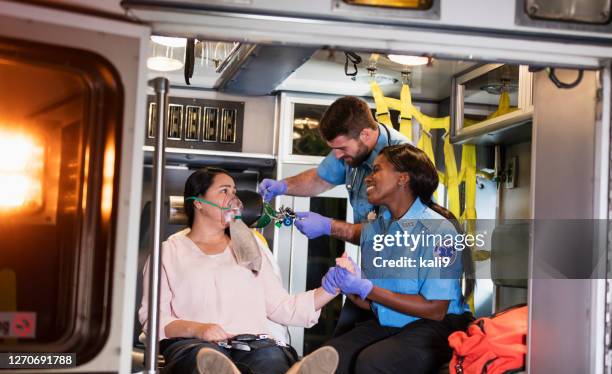 paramedics helping woman in ambulance - emergency first response stock pictures, royalty-free photos & images