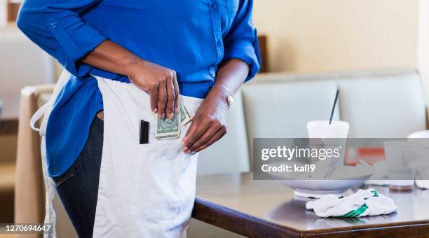waitress in restaurant pocketing her tip - gratuity stock pictures, royalty-free photos & images