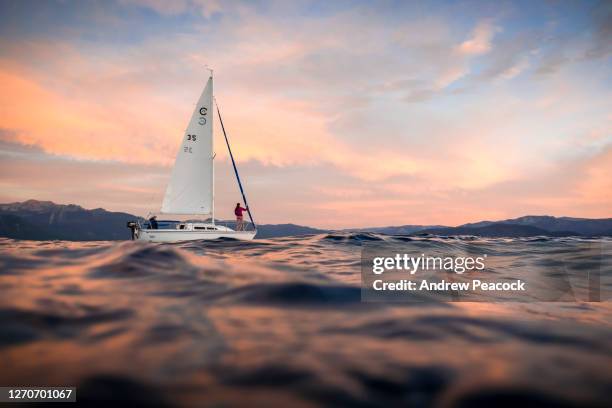 a sailboat on lake tahoe at sunset. - サウスレイクタホ ストックフォトと画像