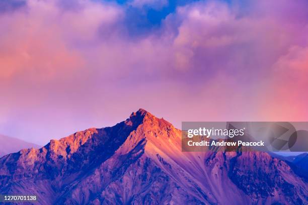 a mountain lit by the setting sun in denali national park, alaska, usa - denali nationalpark stock-fotos und bilder