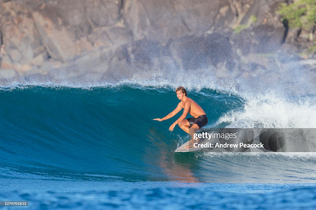 Young man surfing in sea