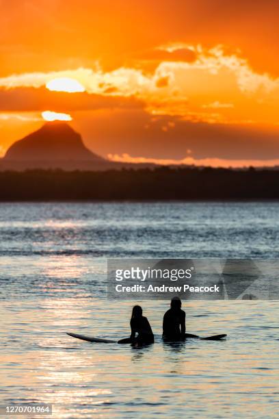 two surfers wait for a wave at sunset. - sunshine coast australia 個照片及圖片檔