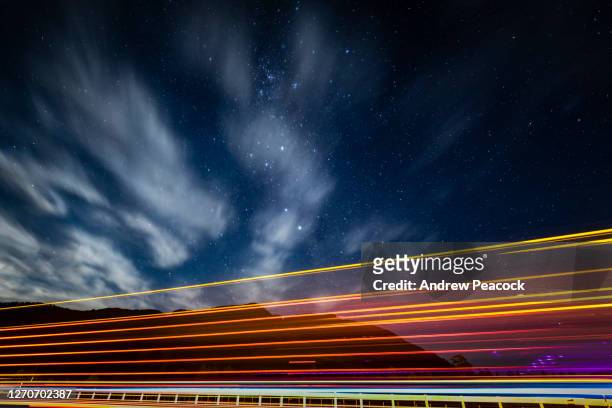 light trails of passing truck under starry night sky - timelapse new zealand stock pictures, royalty-free photos & images