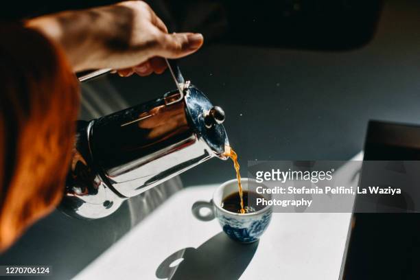 pouring espresso coffee into an espresso cup with a mocha pot. - mattina foto e immagini stock