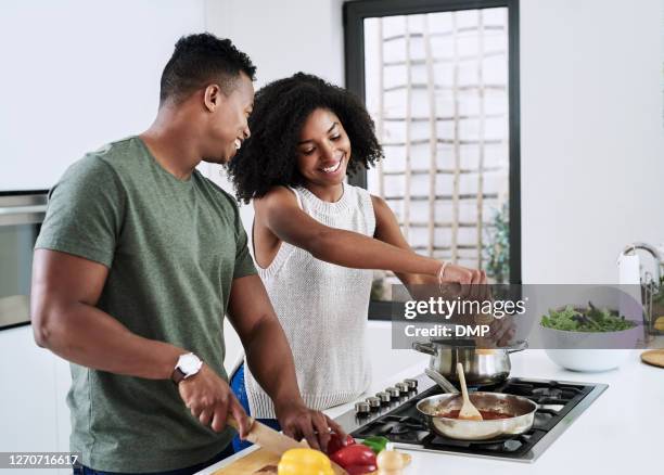 we share a common love for food - young couple cooking stock pictures, royalty-free photos & images