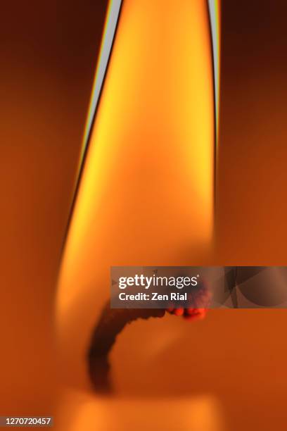 single white candle burning close-up focused on flame and wick in vertical format - zen rial stock pictures, royalty-free photos & images