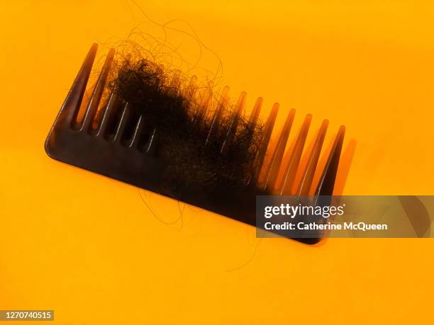 comb with many strands of hair in comb’s teeth - pick tooth photos et images de collection