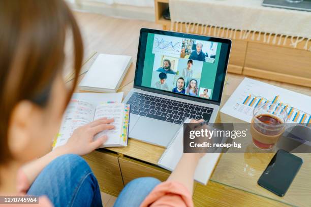 female student joining distant e-learning class via video call on laptop in living room at home - acquaintance via the internet stock pictures, royalty-free photos & images