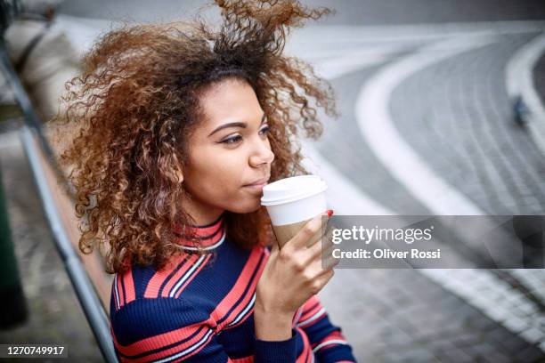 young woman relaxing in the city with takeaway coffee - take away coffee cup stock pictures, royalty-free photos & images