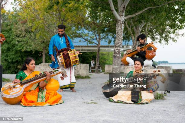 performance of veena music by lake ontario in toronto, canada - veena stock pictures, royalty-free photos & images